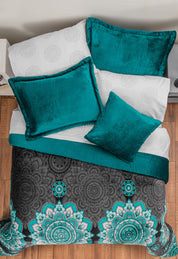 The Coordinado de Cobertor Supremo Tíbet de Intima Hogar, con cojines y manta en terciopelo teal, sábanas blancas con mandalas y cobertor franela negro y teal, luce acogedor sobre piso de madera.