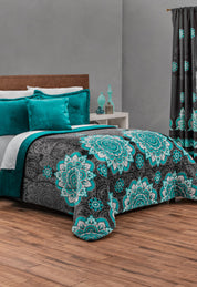 A neatly made bed with the Coordinado de Cobertor Supremo Tíbet by Intima Hogar in teal, gray, and black mandala pattern, matching curtain, teal and white pillows, nightstand, and teal vases creates a stylish look.