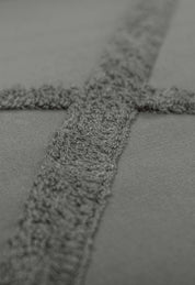 Close-up of the Juego de Edreduvet Bordado Hamburgo by Intima Hogar, featuring soft gray fabric with a raised cross pattern—ideal for a minimalista juego de cama.