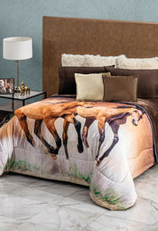 A neatly made bed with a brown headboard, white and brown pillows, and the Cobertor Digital Ultra Suave Caballos by Intima Hogar featuring running horses. The room includes a nightstand with a lamp, decorative horse, and photo frame.