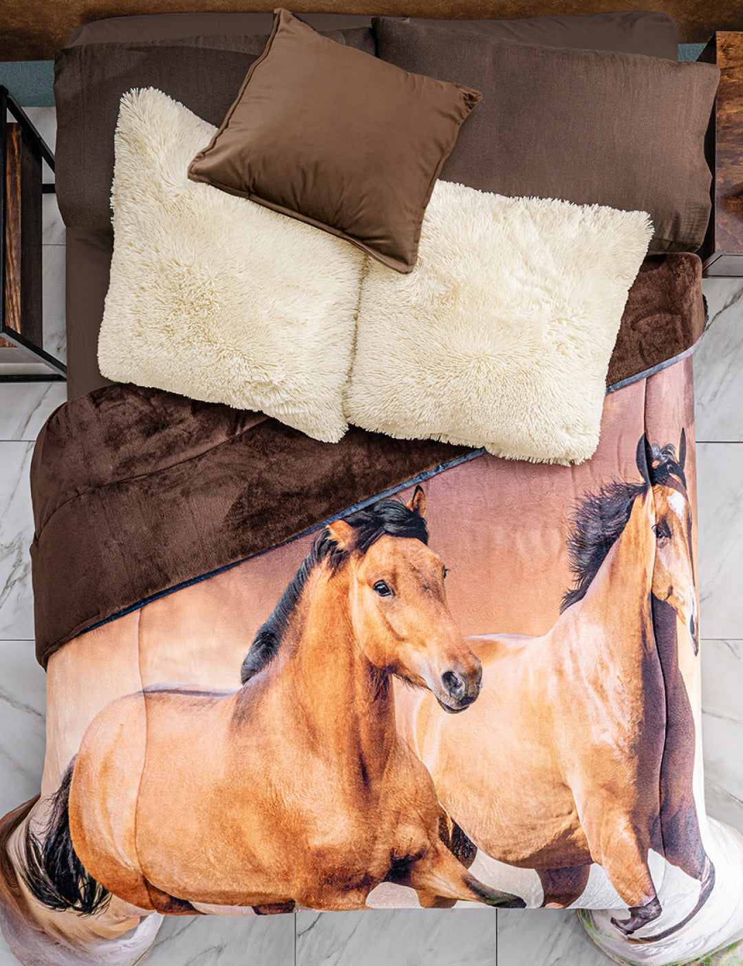 A neatly made bed with brown pillows, white cushions, and the Cobertor Digital Ultra Suave Caballos by Intima Hogar, featuring a realistic print of two running horses. The crisp white tile floor adds a striking contrast.