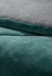Close-up of two soft, textured fabric surfaces—light gray above and teal below—showcasing the Cobertor Flannel Extra Suave Mediterráneo by Intima Hogar with its smooth, velvety look and elegante diseño doble vista.