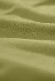 A close-up of the Intima Hogar Cobertor Flannel Ligero Ontario Verde shows its soft, light green fabric with a velvety texture, gentle folds, and plush surface for lasting comfort.