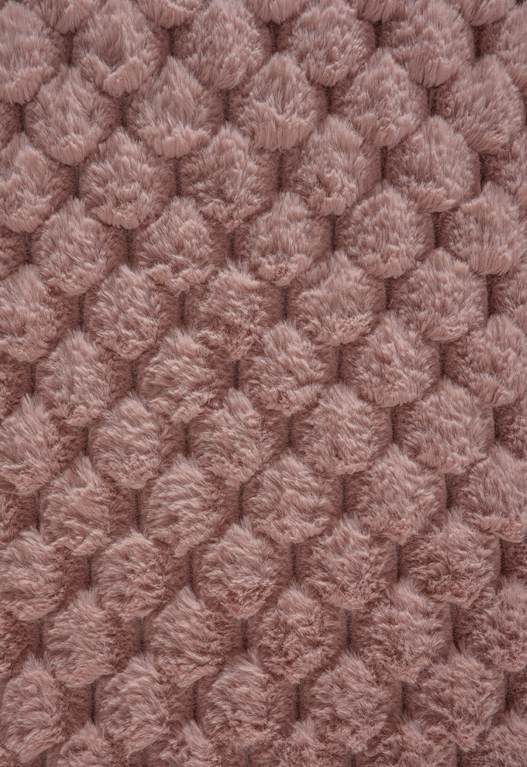 Close-up of the Cobertor Platinum Extra Suave Aruba by Intima Hogar: a plush, ultra-soft texture with raised, fluffy bumps in muted pink—perfect for a cozy winter blanket and an inviting, comfy touch.