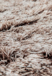 Close-up of the soft, fluffy texture of the Intima Hogar Cobertor Platinum Extra Suave Glacial, featuring beige and brown tones with varied strands for a cozy, inviting look.