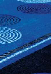 A close-up of the Cobertor Flannel Extra Suave Sfera by Intima Hogar shows its blue textured design with white and black circular patterns and wavy lines—ideal for modern bedrooms.