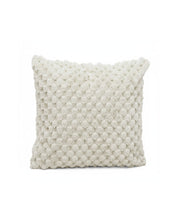 El cojín Nickel de Intima Hogar es rectangular, color off-white, con textura de pompones elevados en toda la superficie, brindando suavidad y un diseño elegante. Ideal para decorar cualquier espacio.