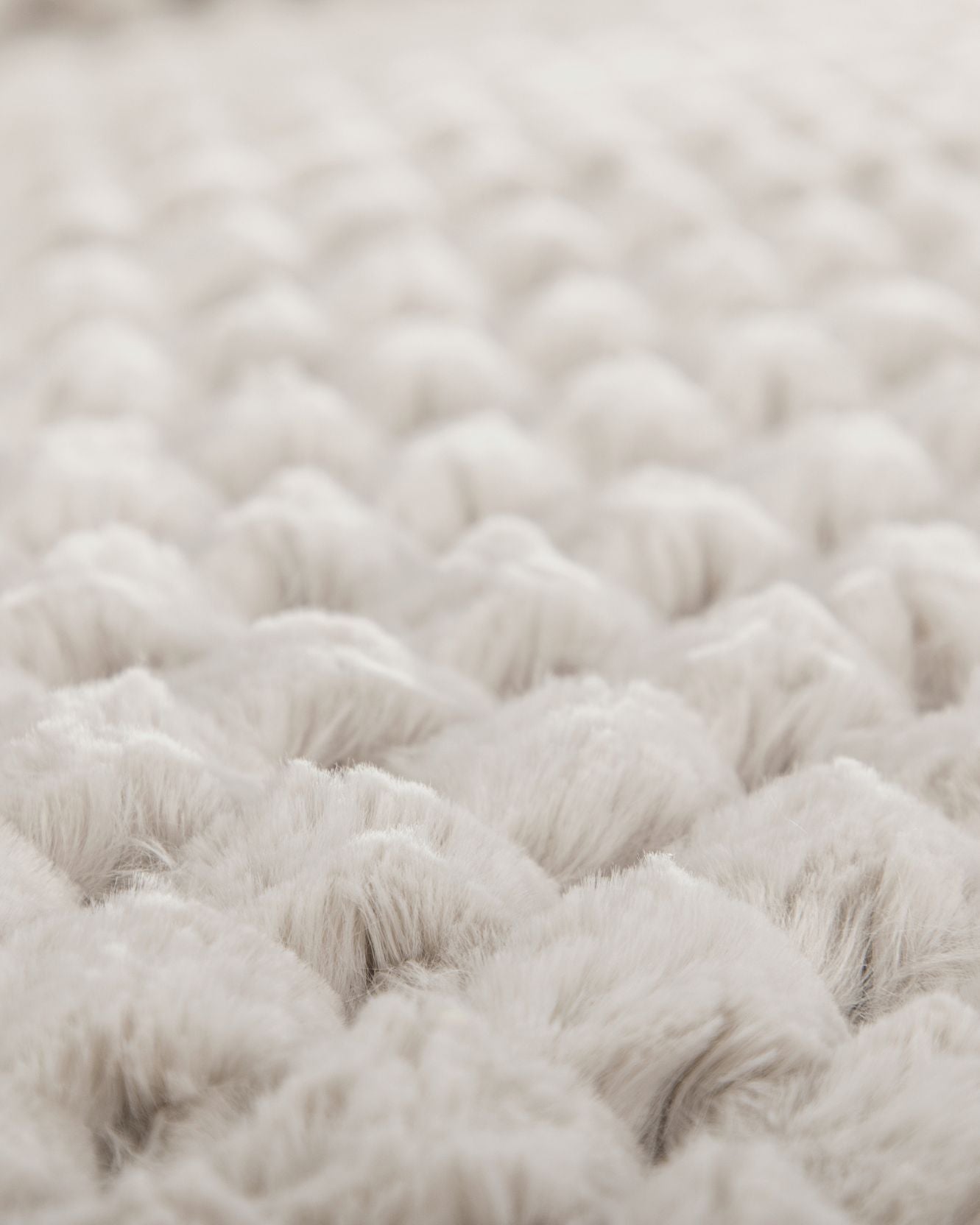 Close-up of the Cojín Nickel by Intima Hogar: its soft, fluffy white texture and quilted pattern create a cozy, plush look, evoking comfort and warmth—perfect for un elegante diseño de cojín.