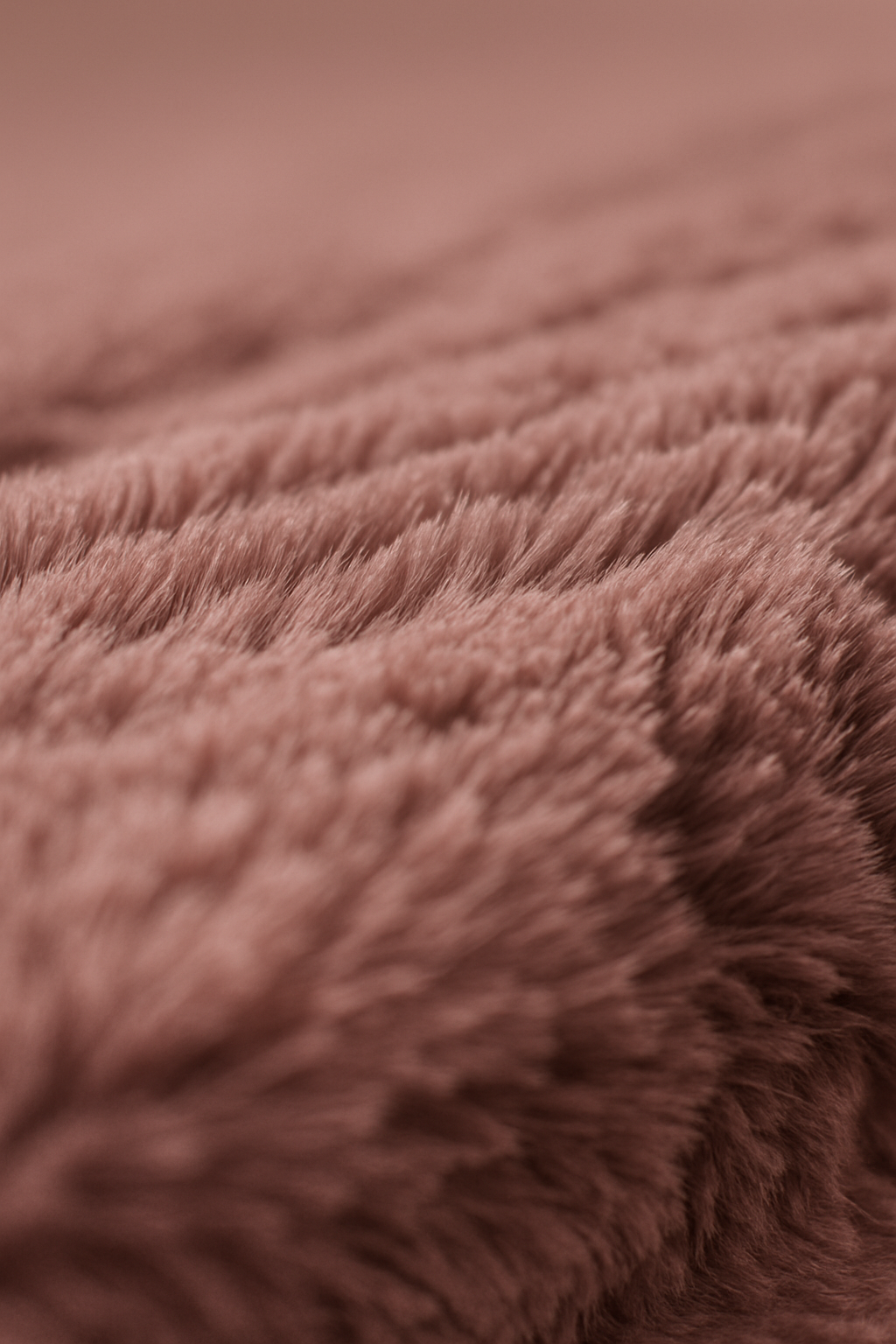 Close-up of soft, fluffy, pinkish-brown fabric with textured fibers and gentle waves—ideal for creating Cojines de Lujo Liverpool by Intima Hogar.