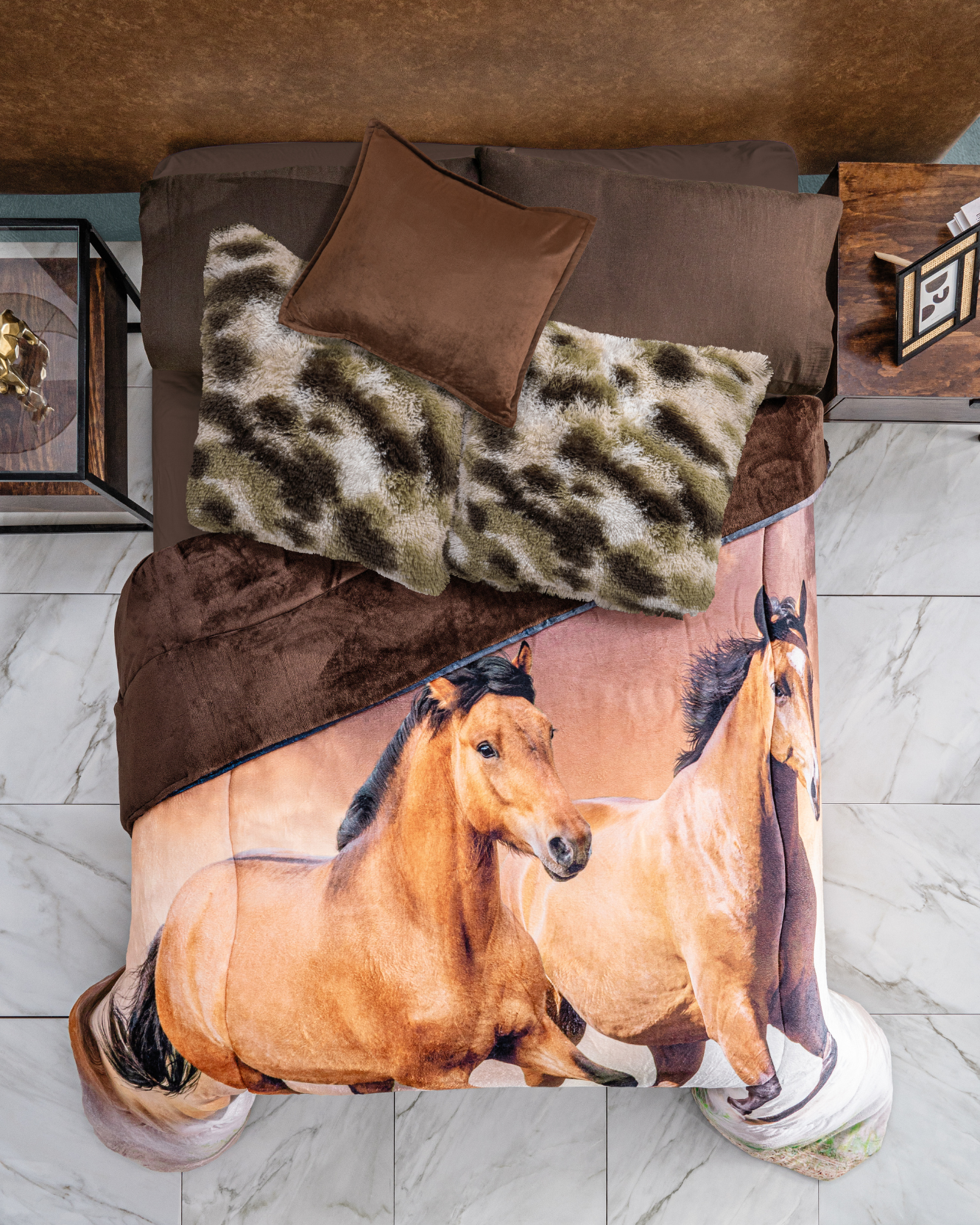 A neatly made bed showcases the Intima Hogar Juego de Cojines de Lujo Finlandia in brown and green, paired with a brown throw and horse-themed comforter. Nightstands with decor sit on a white tiled floor.