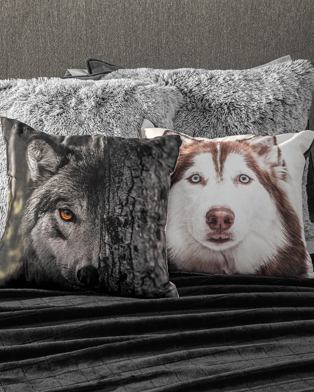 On the bed, two Intima Hogar Cojín Estampado Lobo decorative pillows make a visual statement: one displays a lobo’s face with a tree motif, the other shows a husky close-up. Fluffy gray pillows enhance the look in the background.