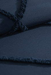 Close-up of the Coordinado de Edredón Luxury Seúl by Intima Hogar, featuring dark blue textured fabric with crisscrossed lines and a fuzzy trim, perfect for adding cozy comfort to your bedding.