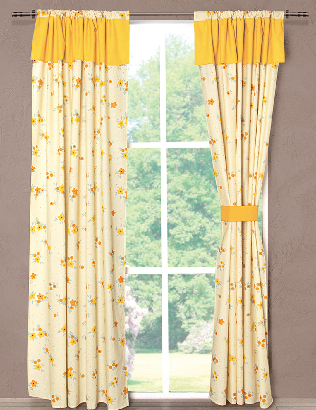 A window adorned with the Juego de Cortinas Girasoles by Intima Hogar features light beige curtains with a yellow floral pattern and solid yellow valances, tied back on one side, allowing natural light and a view of greenery.