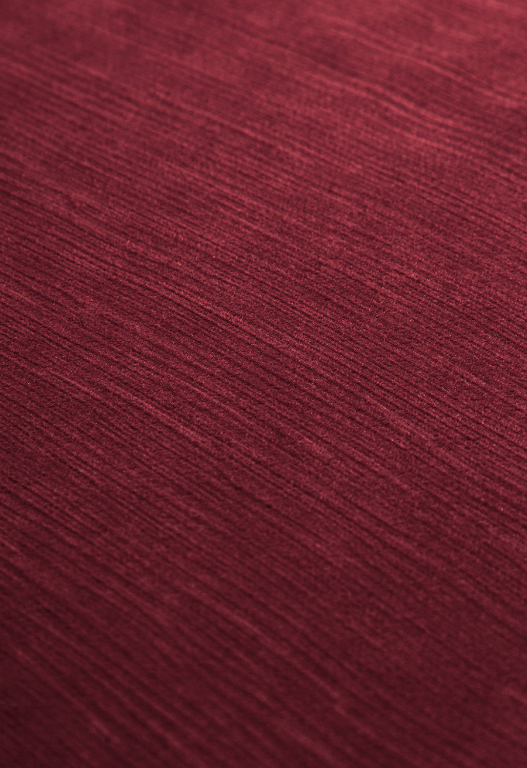 Close-up of the Edredón Súper Suave Janeiro by Intima Hogar: textured red fabric with subtle horizontal lines and a soft, matte finish, perfect for a cozy winter upgrade.