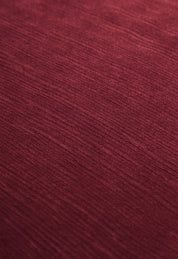 Close-up of the Edredón Súper Suave Janeiro by Intima Hogar: textured red fabric with subtle horizontal lines and a soft, matte finish, perfect for a cozy winter upgrade.