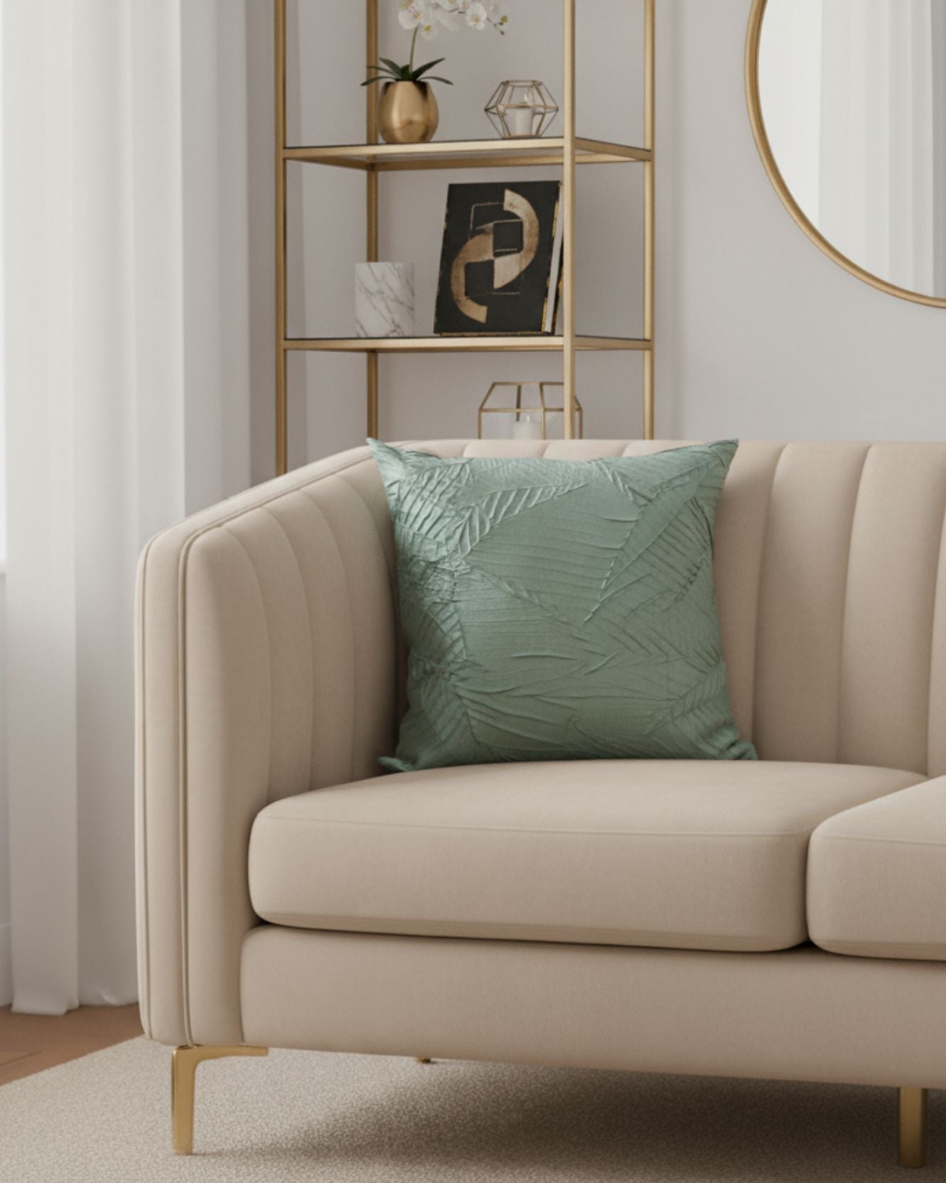 A modern beige sofa with the light green Funda de Cojín Osaka by Intima Hogar sits before a gold shelving unit and round mirror in a bright living room with white curtains, neutral decor, and unique interior design details.