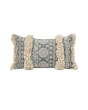 The Funda de Cojín Yadida by Intima Hogar is a rectangular pillow cover with gray and white estampados decorativos and two wide, textured beige franjas con flecos running vertically across the front.