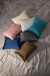 A Funda de Almohada Ensueño Gris Oxford by Intima USA adds a touch of elegance and comfort to the cama with rumpled gray sheets, enhancing the habitación's cozy ambiance.