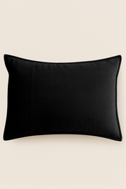 La Funda de Almohada Ensueño Negro de Intima Hogar presenta un diseño rectangular en negro con tela suave y esquinas redondeadas, ideal para descanso elegante en cualquier habitación.
