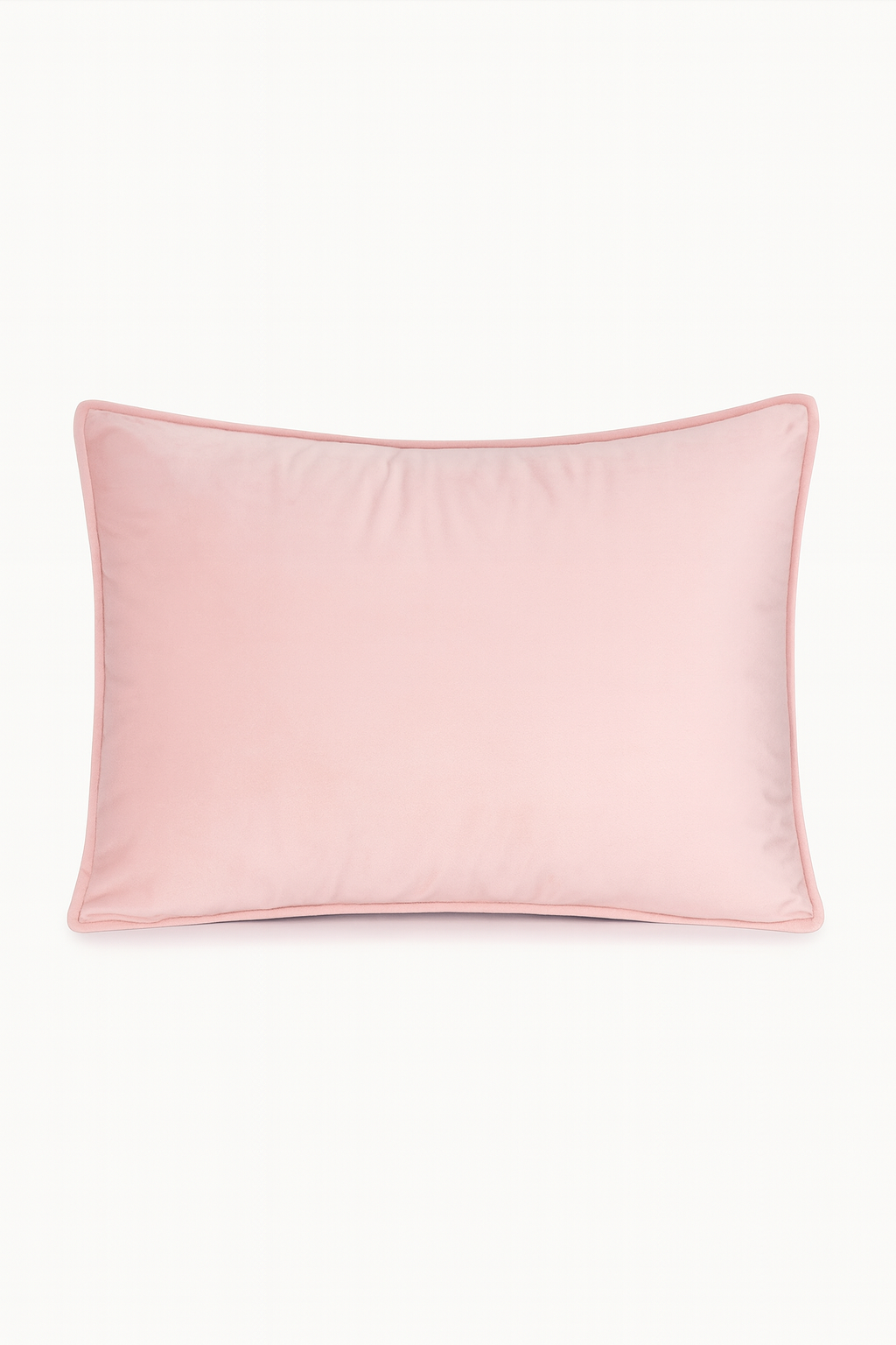 La Funda de Almohada Ensueño Rosa de Intima Hogar, rectangular y de suave textura, en tono rosa claro con ribete rosado más oscuro, es ideal para el descanso en cualquier habitación. Se muestra sobre fondo blanco.