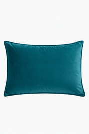 La Funda de Almohada Ensueño Verde de Intima Hogar es rectangular, de terciopelo verde y bordes redondeados, ideal para la cama o dormitorio; se muestra sobre un fondo blanco.