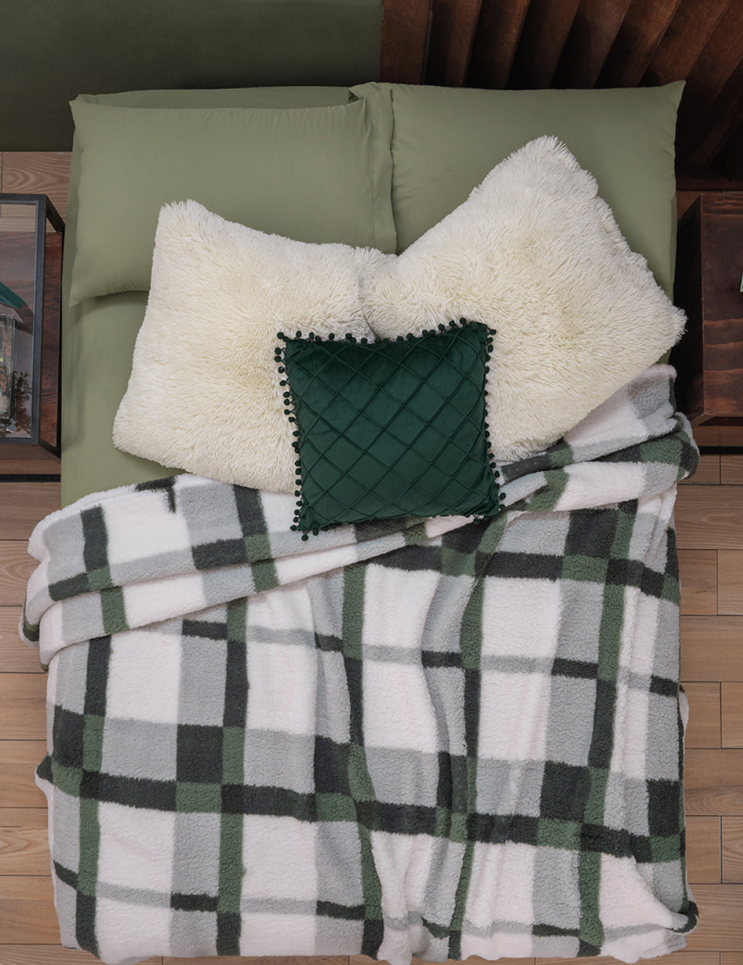 Overhead view of a bed with green pillows and the Juego de Cobertor Flannel Ligero Ottawa by Intima Hogar, featuring white and green plaid flannel, ideal for invierno comfort.