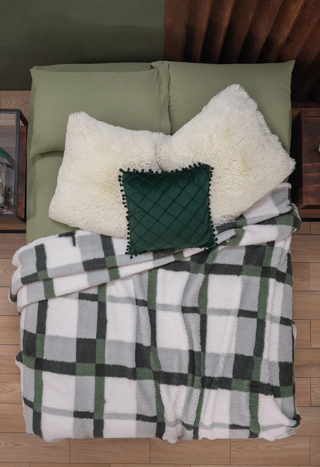 Overhead view of a bed with green pillows and the Juego de Cobertor Flannel Ligero Ottawa by Intima Hogar, featuring white and green plaid flannel, ideal for invierno comfort.