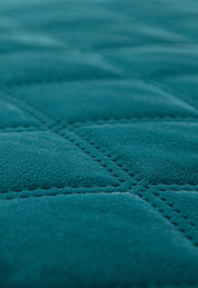 Close-up of the Juego de Cobertor Velvet Lovett Verde by Intima Hogar, featuring a soft, teal velvet finish with a quilted grid pattern and visible stitching—perfect for cozy, decorative comfort.