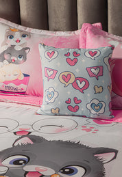 The Juego de Edredón Lindo Gatito by Intima Hogar es un edredón infantil en rosa y azul con gatos, corazones y burbujas; incluye un cojín cuadrado con patrones divertidos y otro con dos gatitos en una taza rosa "Meow" para una habitación acogedora.