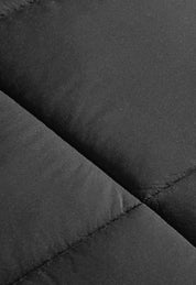 Close-up of black quilted fabric with visible stitching and a matte texture, perfect for the Juego de Edredón Marco de Intima Hogar, un edredón de microfibra con calidez ligera y diseño moderno.