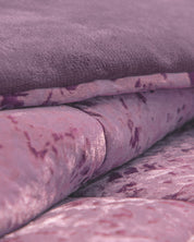 Close-up of the Cobertor Velvet Ice Deluxe Amatista by Intima Hogar, featuring soft, folded pink and purple velvet fabric with a plush, textured surface and a slight sheen.