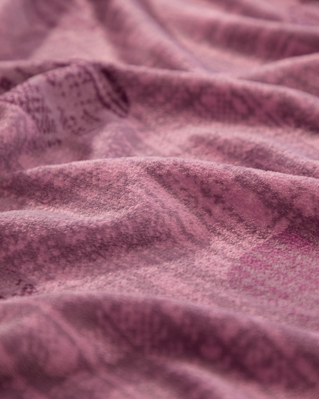 Close-up of the Cobertor Flannel Ligero Marruecos by Intima Hogar, showcasing its soft, textured pink fabric with gentle folds and subtle patterns that evoke warmth and comfort.