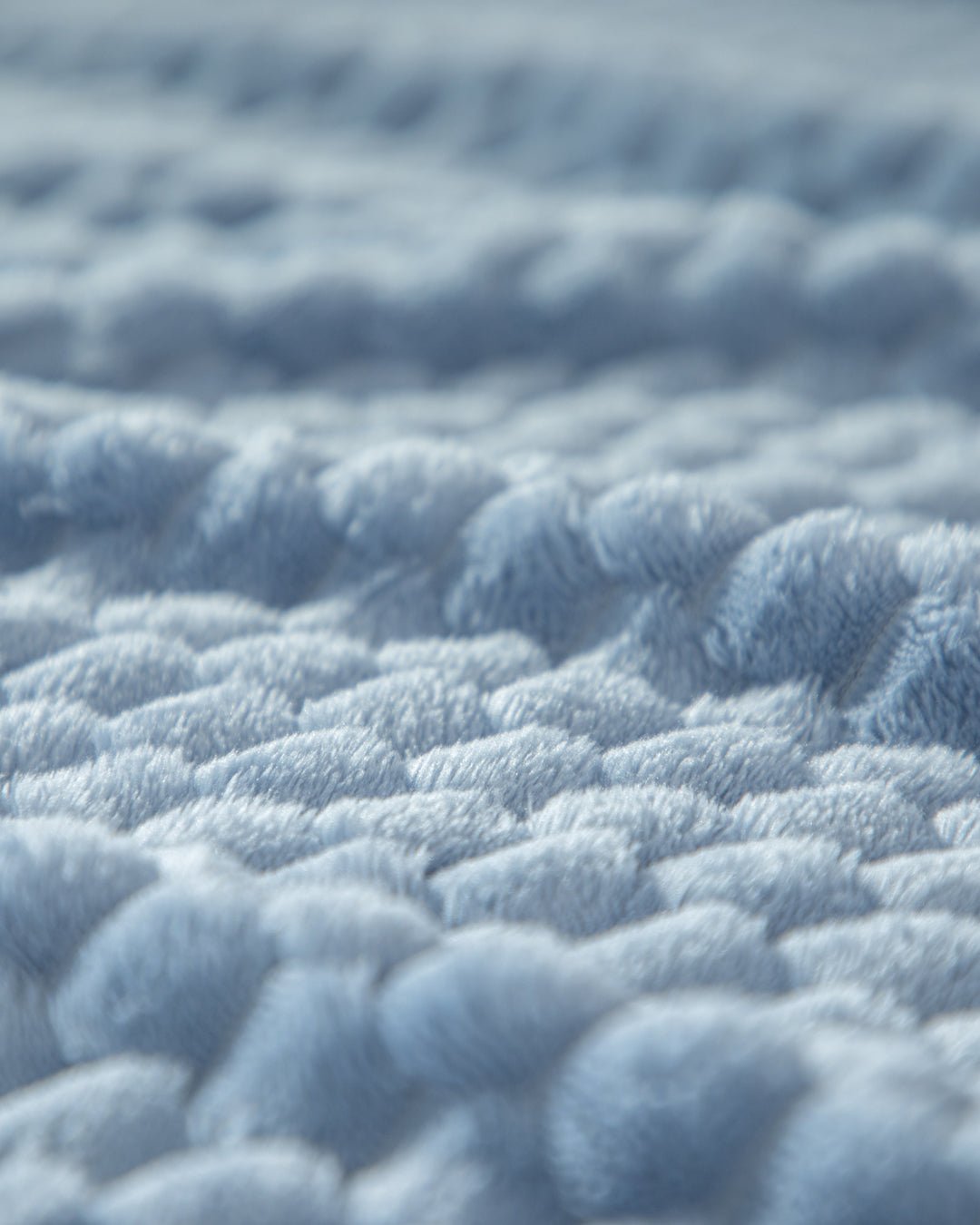 Close-up of the Cobertor Flannel Ligero Niagara by Intima Hogar, featuring soft, light blue textured fabric with raised, fluffy wave-like patterns for a cozy and plush look.