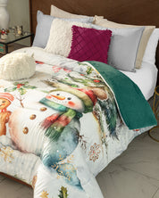 A neatly made bed features the Cobertor Flannel Extra Suave Nieve from Intima Hogar, snowman-themed ropa de cama, several pillows including white and magenta ones, and a green blanket, creating a festive diseño invernal atmosphere in a cozy bedroom—perfect inspiration for renovar habitación this season.