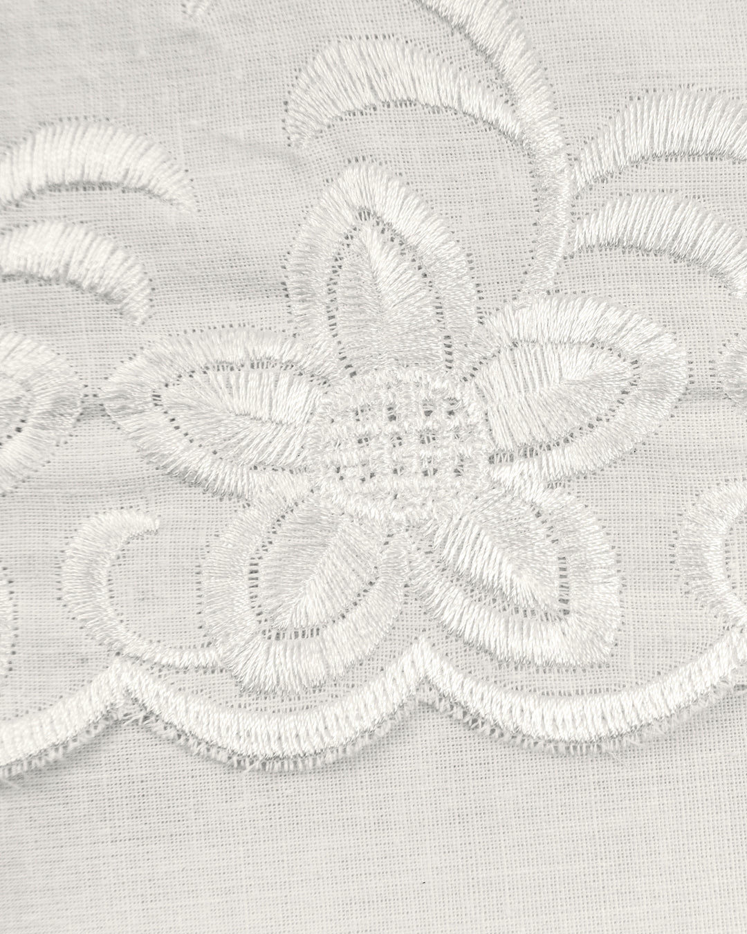 Close-up of the delicate white floral embroidery on sheer fabric from the Juego de Edredón Bordado Fidanza by Intima Hogar, ideal for adding elegance to your dormitorio or enhancing edredón and fundas decorativas.