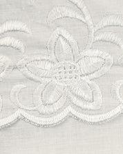 Close-up of the delicate white floral embroidery on sheer fabric from the Juego de Edredón Bordado Fidanza by Intima Hogar, ideal for adding elegance to your dormitorio or enhancing edredón and fundas decorativas.