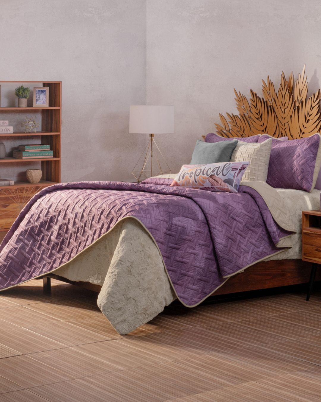 A neatly made bed features the Edredón Ligero Provenza by Intima Hogar in beige and purple, complemented by decorative pillows and a leaf-shaped wooden headboard. A nightstand and bookshelf complete this cozy, modern Provenza-inspired room.