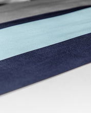 Close-up of the Juego de Edredón Luca by Intima Hogar, featuring a minimalist and abstract pattern with horizontal stripes in light blue, dark blue, gray, and white tones.