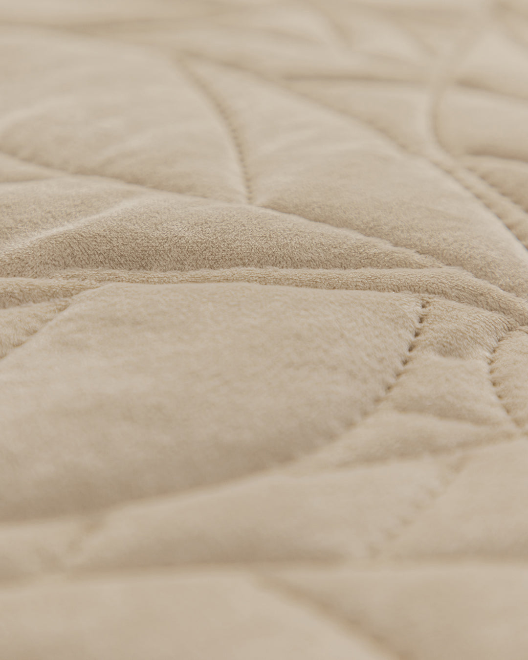 Close-up of the Juego de Edredón Velvet Vida by Intima Hogar, featuring beige quilted fabric with a soft velvet texture and stitched geometric patterns.