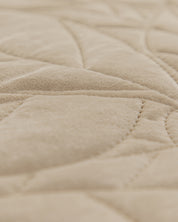 Close-up of the Juego de Edredón Velvet Vida by Intima Hogar, featuring beige quilted fabric with a soft velvet texture and stitched geometric patterns.