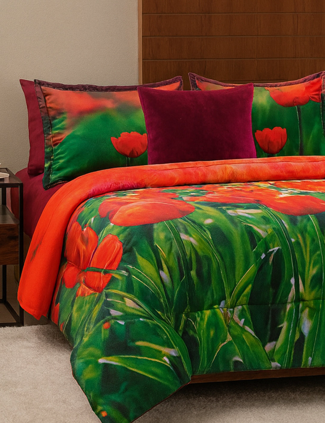 The Juego de Cobertor Lisse de Intima Hogar destaca con flores rojas y hojas verdes, acompañado de un cojín magenta sólido, ideal para quienes aman los cobertores microfibra y buscan estilo vibrante en su habitación.