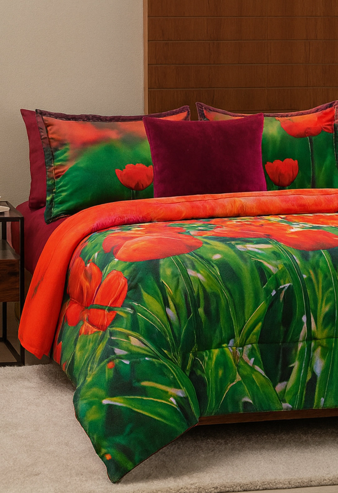 The Juego de Cobertor Lisse de Intima Hogar destaca con flores rojas y hojas verdes, acompañado de un cojín magenta sólido, ideal para quienes aman los cobertores microfibra y buscan estilo vibrante en su habitación.