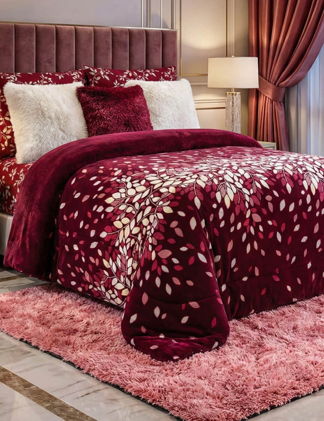 A luxurious bedroom features the Intima Hogar Cobertor Flannel Extra Suave Tinto with matching pillows, a tufted headboard, white furry accents, a pink shaggy rug, bedside lamp, and floor-length curtains.